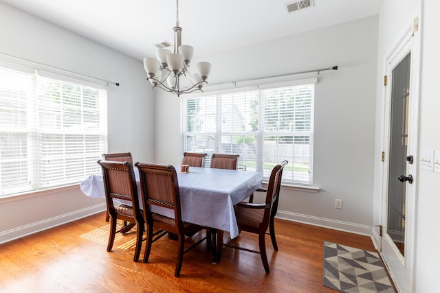 dining space with a wealth of natural light, visible vents, and wood finished floors