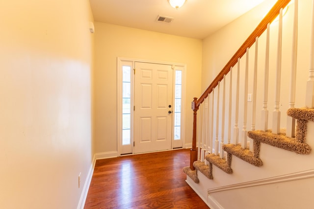 entryway featuring stairs, wood finished floors, visible vents, and baseboards