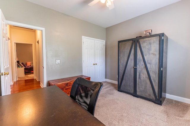 carpeted home office featuring baseboards and a ceiling fan