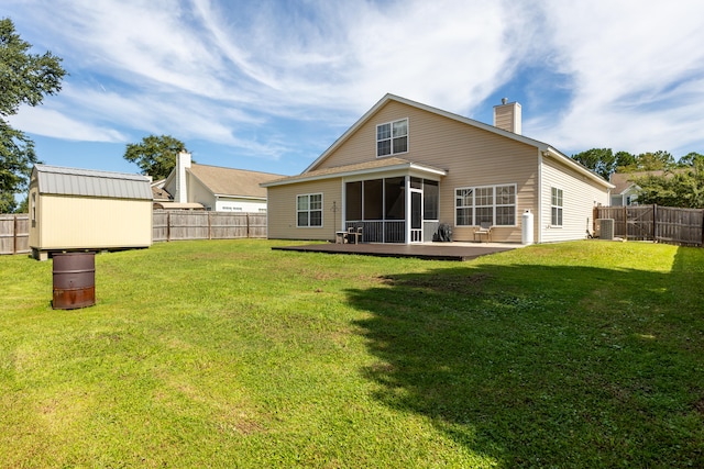 back of house with an outbuilding, central AC unit, a lawn, and a fenced backyard