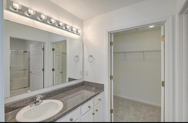 159 Townsend Way, Summerville, SC 29483 - bathroom featuring vanity, a walk in closet, a textured ceiling, and a shower with door