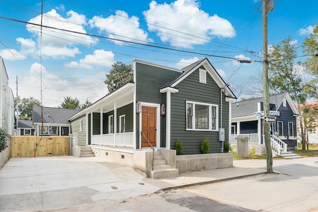 view of front of home featuring a porch and fence