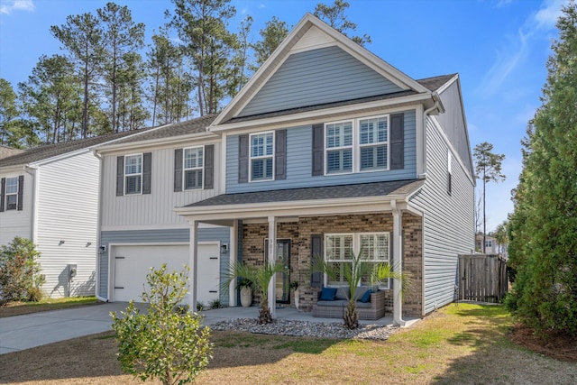 view of front of house with brick siding, covered porch, fence, a garage, and driveway