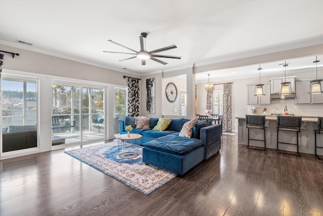 living area with ornamental molding, dark wood-type flooring, and visible vents