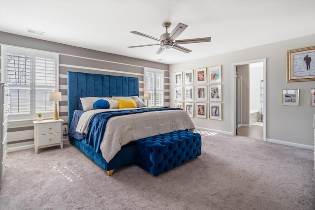 carpeted bedroom featuring ensuite bathroom, a ceiling fan, visible vents, and baseboards