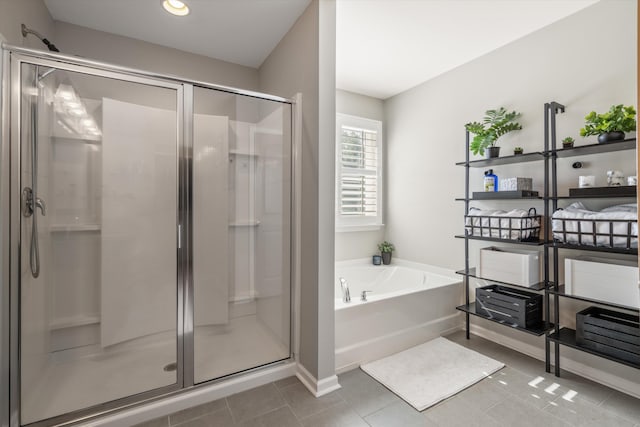 full bathroom featuring tile patterned flooring, a shower stall, and a bath