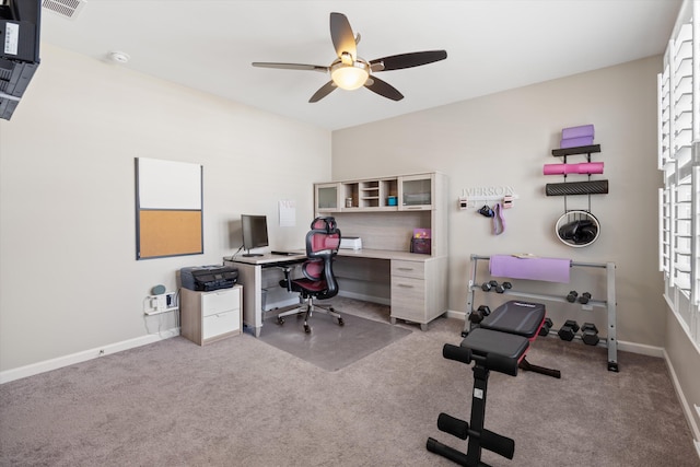 office space featuring light carpet, ceiling fan, visible vents, and baseboards