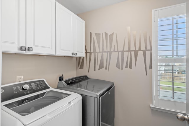 clothes washing area featuring cabinet space and separate washer and dryer