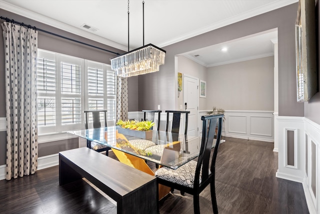 dining area with a decorative wall, a wainscoted wall, dark wood-type flooring, visible vents, and ornamental molding