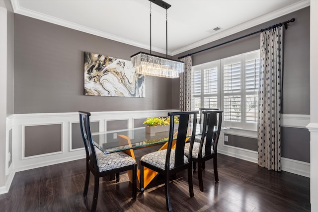 dining space featuring visible vents, crown molding, and wood finished floors