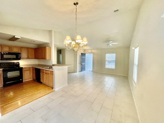 kitchen featuring open floor plan, light countertops, lofted ceiling, hanging light fixtures, and black appliances