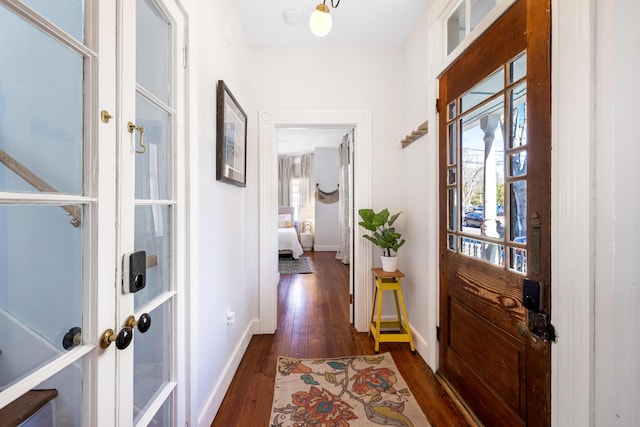 entrance foyer with dark wood-style flooring and baseboards