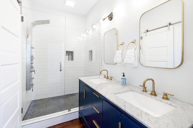 full bathroom featuring a stall shower, a sink, and double vanity