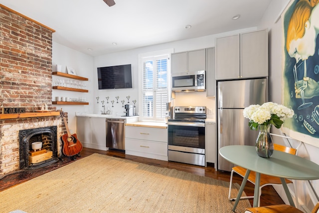 kitchen featuring appliances with stainless steel finishes, light countertops, wood finished floors, and gray cabinetry