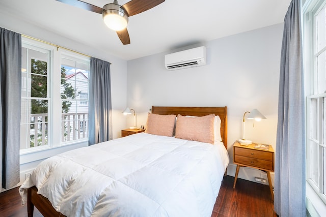 bedroom featuring an AC wall unit, multiple windows, ceiling fan, and wood finished floors