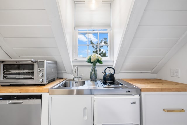 kitchen featuring wood counters, white cabinetry, and stainless steel dishwasher