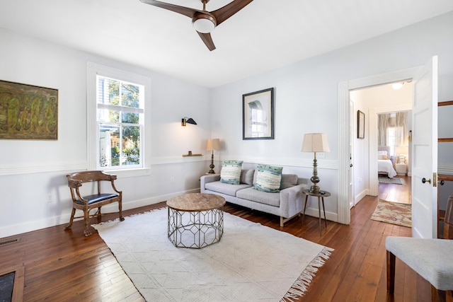 living area featuring a ceiling fan, wood-type flooring, and baseboards