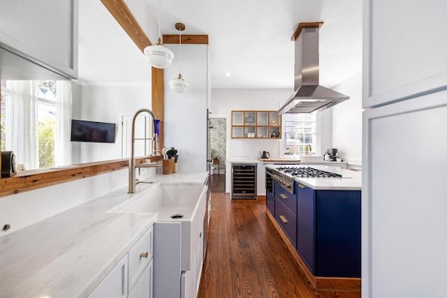 kitchen with wine cooler, stainless steel gas stovetop, dark wood-type flooring, island range hood, and blue cabinets