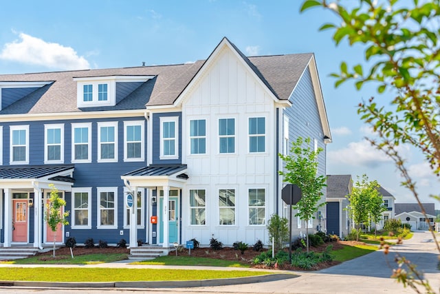 view of front facade with a standing seam roof, a shingled roof, and board and batten siding