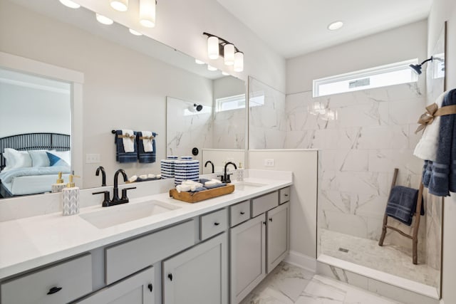 ensuite bathroom with marble finish floor, a sink, a marble finish shower, and double vanity