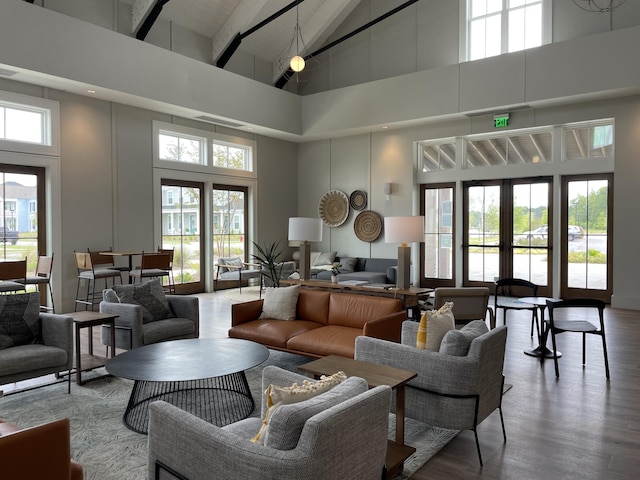 living area featuring french doors, a high ceiling, and wood finished floors