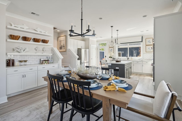 dining room with light wood finished floors, visible vents, a chandelier, and recessed lighting