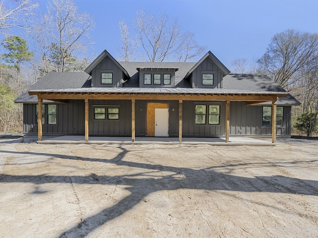 view of front of house with board and batten siding, a shingled roof, and a porch