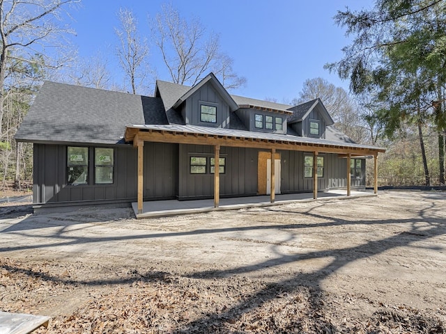 view of front of house featuring board and batten siding and roof with shingles