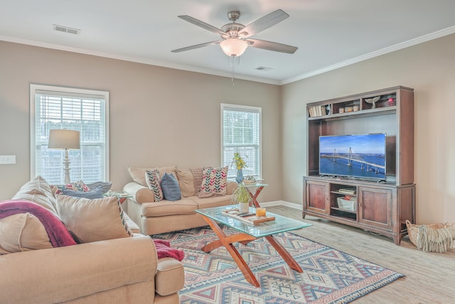 living room featuring ceiling fan, ornamental molding, and light hardwood / wood-style flooring