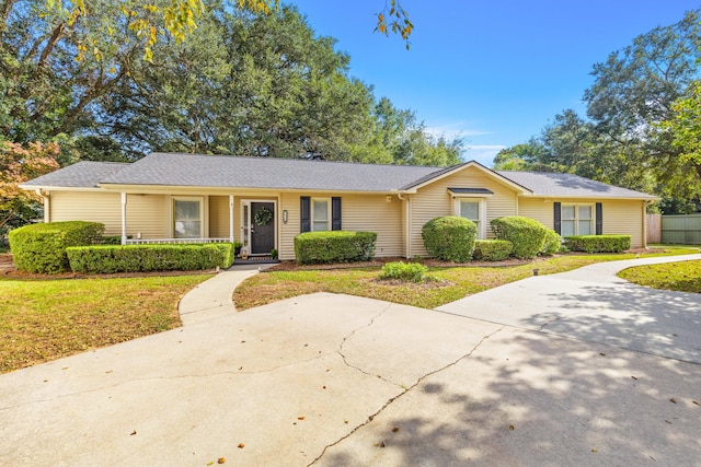 single story home featuring covered porch and a front yard