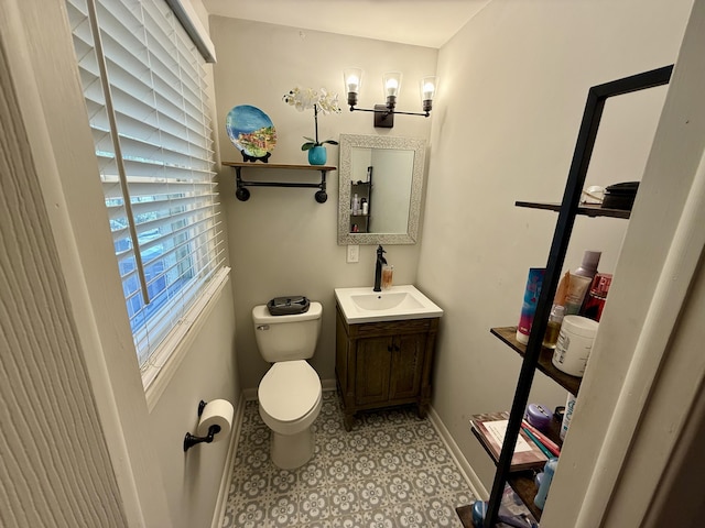 half bath with vanity, toilet, and baseboards