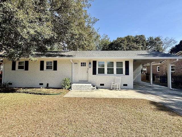 ranch-style home with a carport, crawl space, brick siding, and concrete driveway