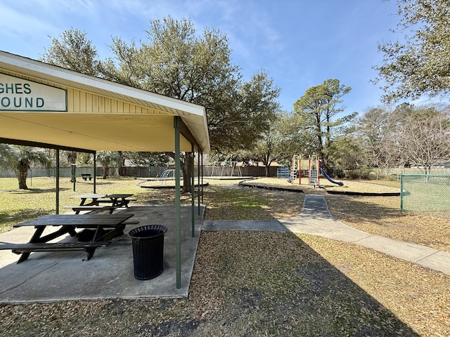 view of community featuring playground community and fence