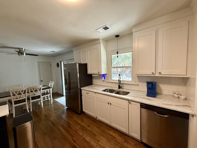 kitchen featuring visible vents, hanging light fixtures, stainless steel appliances, white cabinetry, and a sink