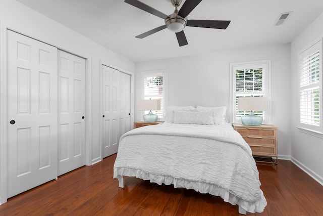 1514 Village Sq, Mount Pleasant, SC 29464 - bedroom featuring two closets, hardwood / wood-style flooring, ceiling fan, and baseboards