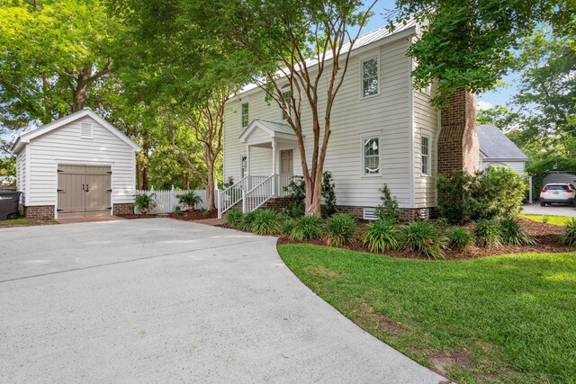 1514 Village Sq, Mount Pleasant, SC 29464 - view of front of property with an outdoor structure, a front yard, driveway, and a chimney