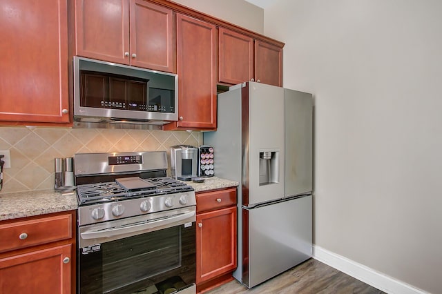 3801 Canary Ct, North Charleston, SC 29420 - kitchen featuring stainless steel appliances, tasteful backsplash, light wood finished floors, baseboards, and light stone counters