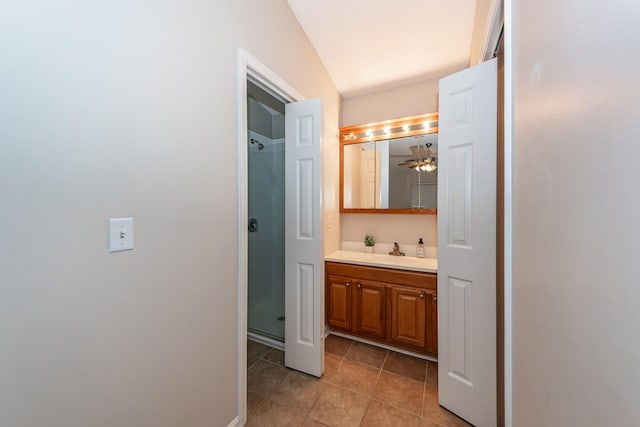 bathroom with ceiling fan, tile patterned flooring, vaulted ceiling, vanity, and a shower with shower door