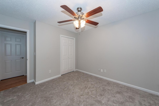 unfurnished bedroom with ceiling fan, light colored carpet, a textured ceiling, and a closet