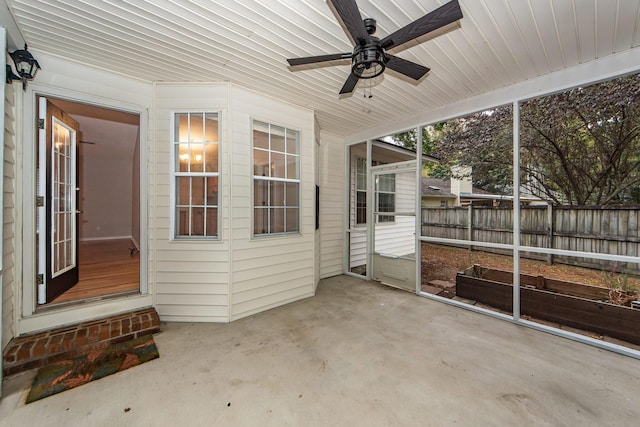 unfurnished sunroom with ceiling fan