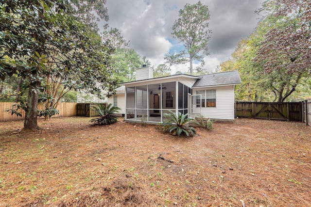 back of house featuring a sunroom and ceiling fan