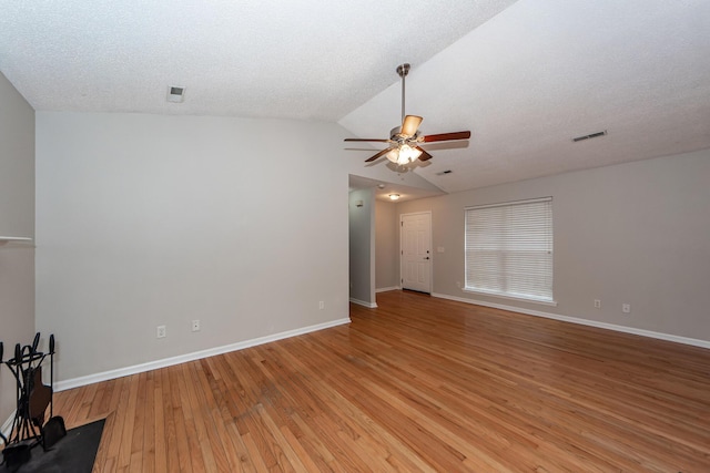 spare room featuring ceiling fan, vaulted ceiling, a textured ceiling, and light hardwood / wood-style flooring