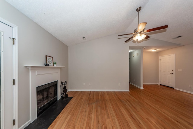 unfurnished living room with wood-type flooring, a textured ceiling, ceiling fan, and lofted ceiling