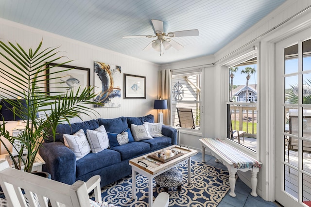 living area featuring tile patterned floors, a ceiling fan, and ornamental molding