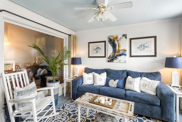 living room with tile patterned flooring, ceiling fan, and ornamental molding