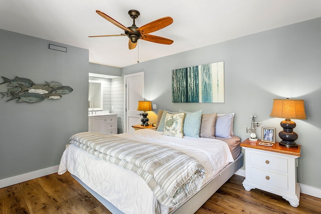 bedroom featuring ceiling fan, ensuite bathroom, baseboards, and wood finished floors