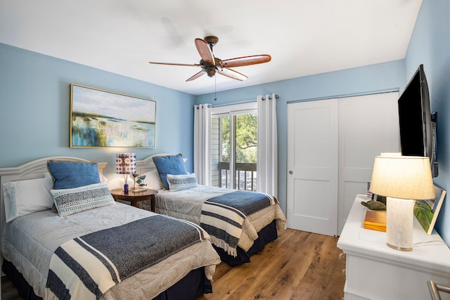 bedroom featuring access to outside, wood finished floors, a closet, and ceiling fan