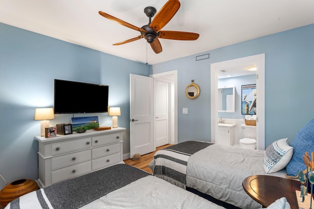 bedroom with ceiling fan, light wood-type flooring, and ensuite bath