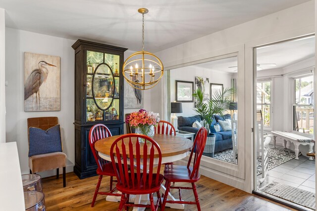 dining space featuring light wood-type flooring and a notable chandelier