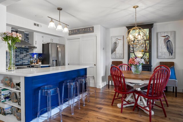 kitchen with white cabinetry, a chandelier, dark hardwood / wood-style floors, and stainless steel refrigerator with ice dispenser